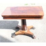 A William IV rosewood fold-over top card table, on faceted column and quadriform base with lion