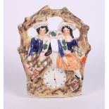 A 19th Century Staffordshire watch group, 7 1/2" high, another 19th Century Staffordshire figure