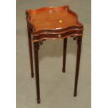 A Chippendale revival mahogany serpentine top occasional table with blind fretted work, fitted one