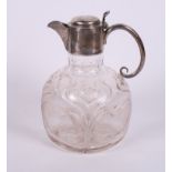 A square section cut glass claret jug with silver mounts