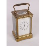 A brass cased carriage clock with white enamel dial and Roman numerals, 5 1/2" high