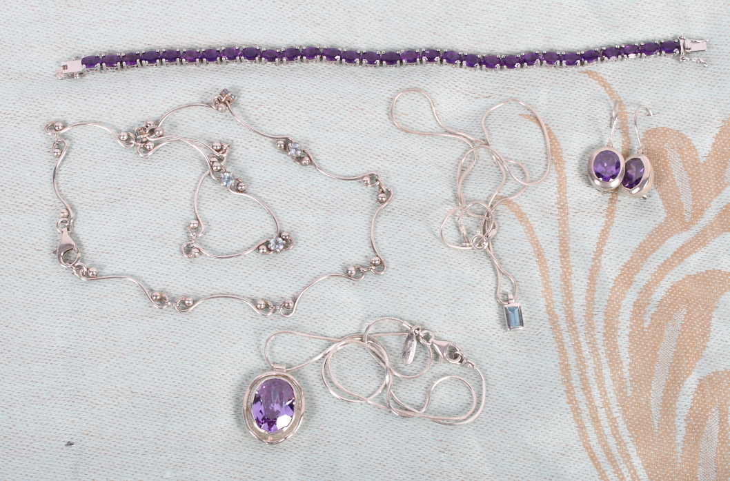 A silver and amethyst tennis bracelet, a silver and amethyst necklace and earring set and two