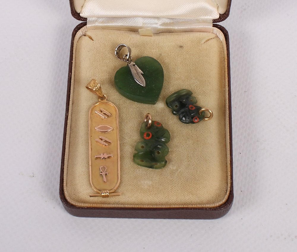 An Egyptian yellow metal cartouche, two jade tiki and a jade heart pendant