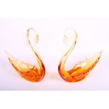 A pair of Whitefriars type amber glass swans, 9" high