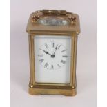 A brass cased carriage clock with white enamel dial and Roman numerals, 4 1/2" high