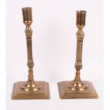 A pair of Georgian brass seamed pillar candlesticks on square bases, 10" high