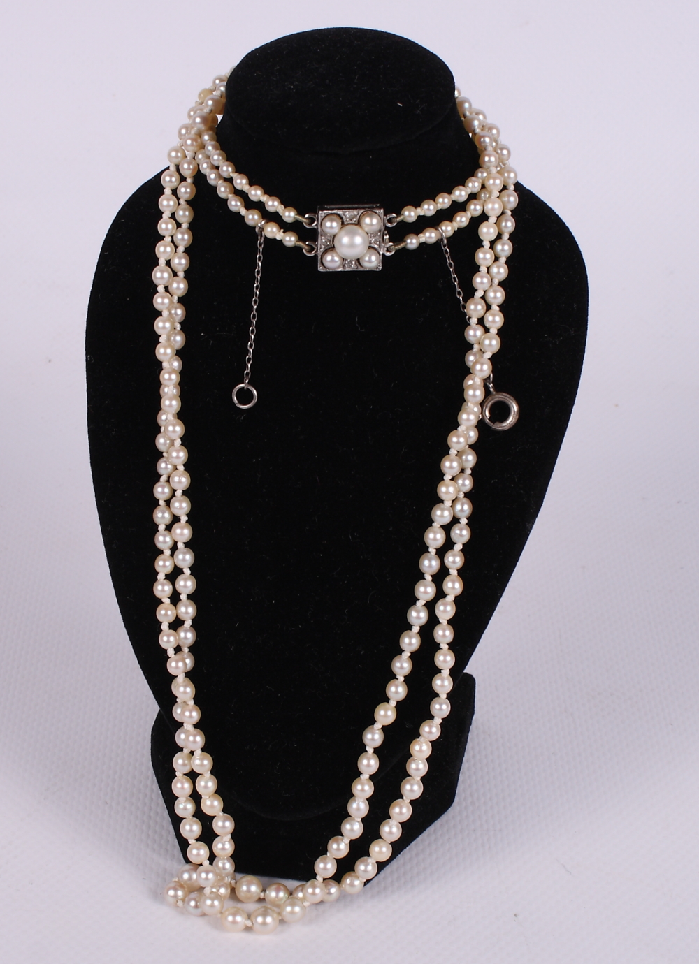 An early 20th Century double string of graduated pearls with white metal, diamond and pearl set