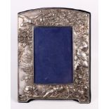 An oriental white metal photograph frame embossed with flowers, birds and buildings, 10 1/2" high