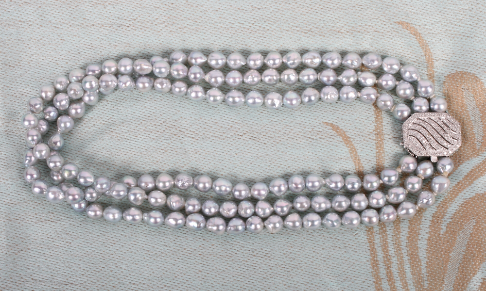 A three-strand cultured pearl choker with 18ct white gold diamond set clasp
