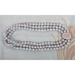 A three-strand cultured pearl choker with 18ct white gold diamond set clasp
