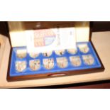 A set of twelve silver "Royal Coat of Arms" shield-shaped medallions, in fitted mahogany case