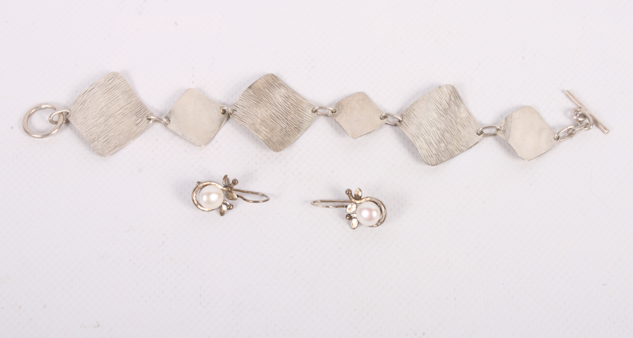 A hammered silver bracelet and a pair of silver earrings/clips set pearls