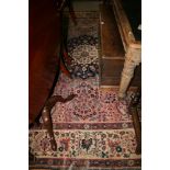 A Persian design carpet decorated central blue and ivory medallion on a pink ground with three