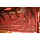 A Persian design rug decorated two lobed medallions and spandrels on a red floral ground and multi-