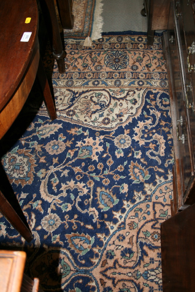 A Persian design carpet decorated central pink medallion on a blue floral ground, 12' x 9' approx (