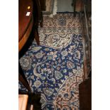 A Persian design carpet decorated central pink medallion on a blue floral ground, 12' x 9' approx (