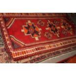 A Caucasian rug decorated three large and four smaller cross-shaped medallions on a red ground