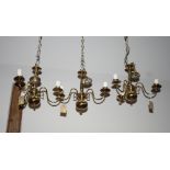 A set of three Cromwellian design brass three-branch centre lights