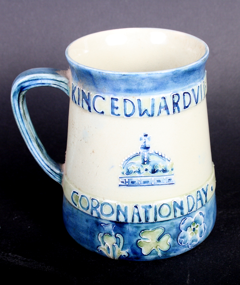 A Moorcroft mug designed by Liberty to commemorate the 1902 Coronation of King Edward VII, 4" high