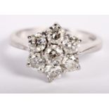 An 18ct white gold and diamond seven stone cluster ring, size K