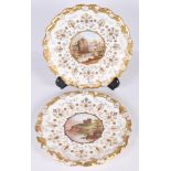 A pair of Coalport wall plates with gilt decorated borders and edges, centres painted named views of