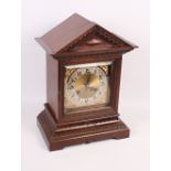 A walnut cased mantel clock with brass dial, 15" high