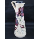 A Moorcroft ewer with chocolate Cosmos design, 19cm high.