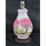 A Walter Moorcroft table lamp with magnolia design, 28cm high.