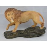 A large Beswick lion upon a rock, model 2554, 33cm wide.