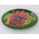 A Walter Moorcroft oval dish with Hibiscus design; 11.5cm oval.