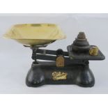 A set of balance scales, 'The Queen' by Weylux, having a brass pan and ten brass weights,