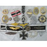 Approximately 20 reproduction WW2 Nazi cap badges and medals.