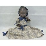 A c1940s black doll having moulded head, painted face and jointed limbs, 38cm in length.