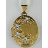 A 9ct oval locket with floral engraving,