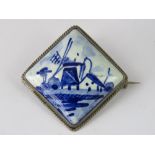 A delft pottery brooch with white metal