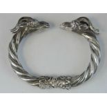 A hinged 900 silver bangle with goat head terminals, bolt locking mechanism in hinge, stamped 900,