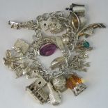 A silver charm bracelet with heart clasp, eighteen charms,