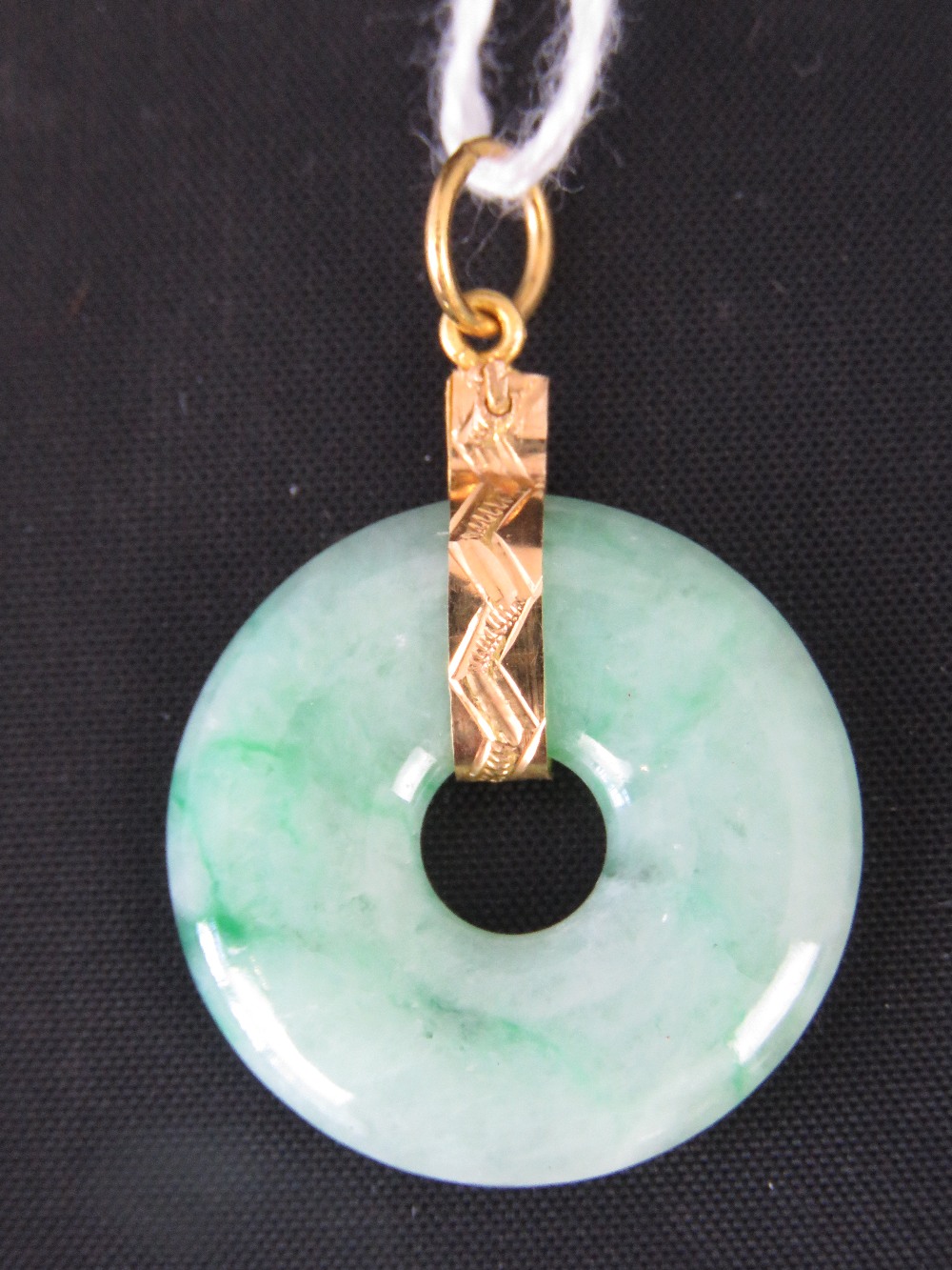 A green jade disk with yellow metal (probably 22ct gold) pendant, 3.5cm long, 4.