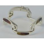 A silver and enamel articulated bracelet, six semi circular panels with inset amber enamelling,