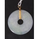 A pale green jade disk with yellow metal (probably 22ct gold) pendant, 6.4cm long, 17.