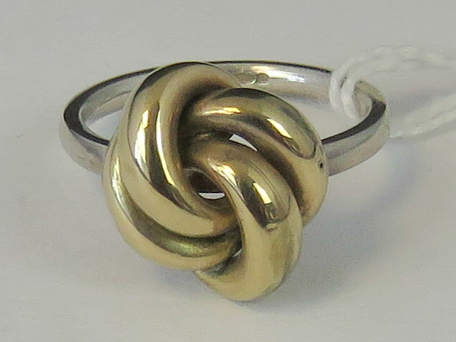 A silver and yellow metal knot ring, sha