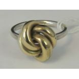 A silver and yellow metal knot ring, sha