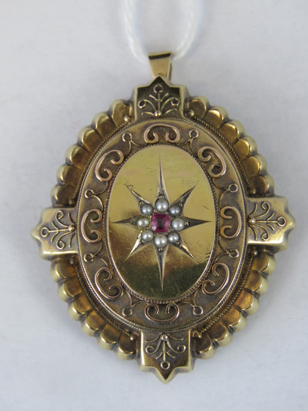 A yellow metal memorial pendant, ruby an