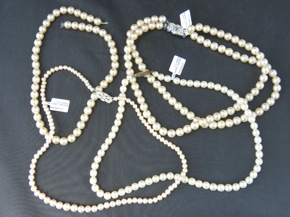 Three faux pearl necklaces; a triple str