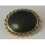 A 9ct gold and onyx brooch, large oval o