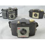 Three vintage Kodak cameras it with plas