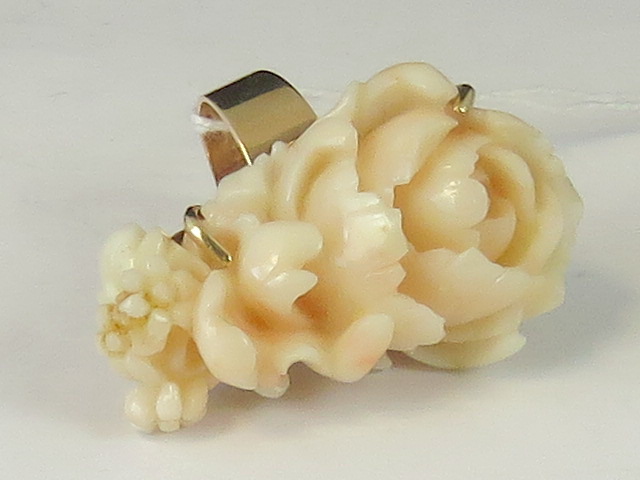 A 14ct gold carved 'angel skin' coral ri