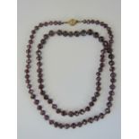 A 9ct gold and faceted garnet bead necklace, 59cm long, clasp stamped 375.