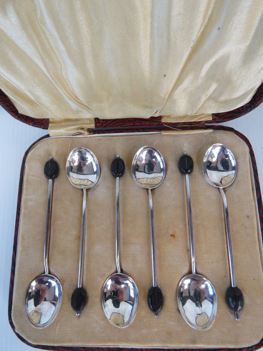 A boxed set of six HM silver coffee bean spoons, Birmingham 1925, maker TW&S.