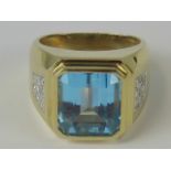 A 14ct gold ring set with large central emerald cut blue stone,